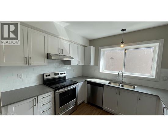 A kitchen with white cabinets and a stove top oven.