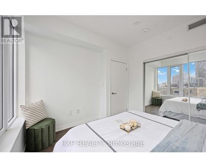 A bedroom with a large bed and a window overlooking a cityscape.