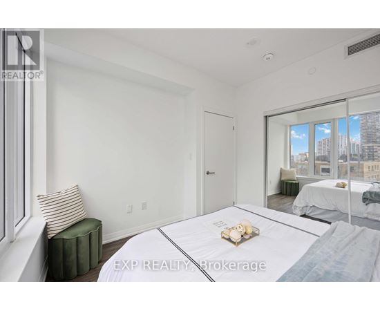 A bedroom with a large bed and a window overlooking a cityscape.