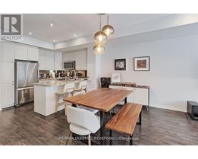 A modern kitchen with a wooden table and chairs.