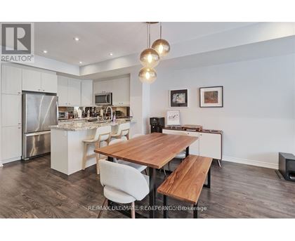 A modern kitchen with a wooden table and chairs.