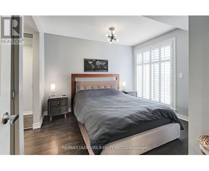 A bedroom with a large bed and a chandelier.