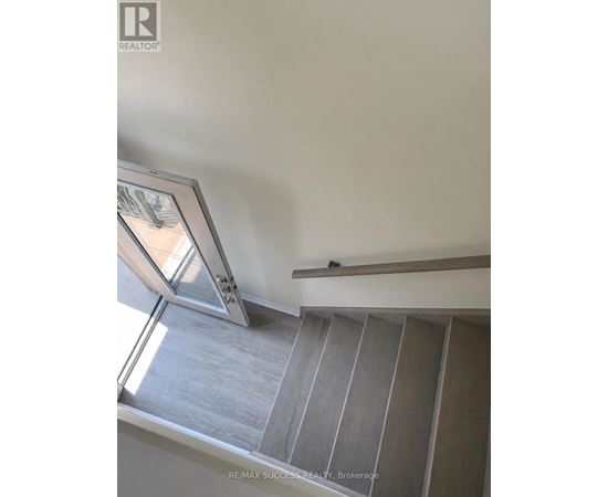 A staircase with a glass door and a wooden handrail.