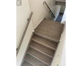 A staircase with wooden steps and a grey railing.