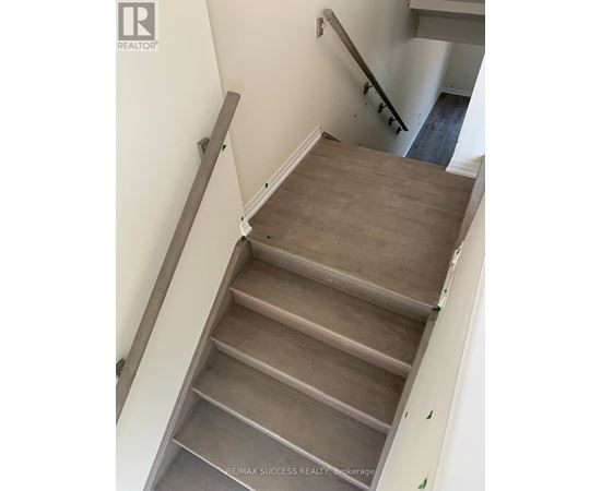 A staircase with wooden steps and a grey railing.