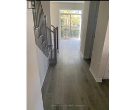 A hallway with a staircase leading to a balcony.