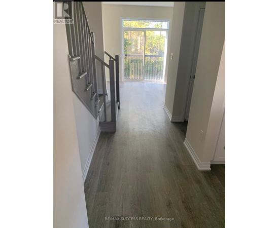 A hallway with a staircase leading to a balcony.