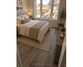A bedroom with a large bed and a view of a deck outside the window.