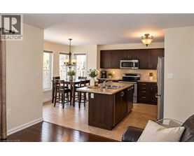 A well-lit kitchen with dark wood cabinets and a central island.