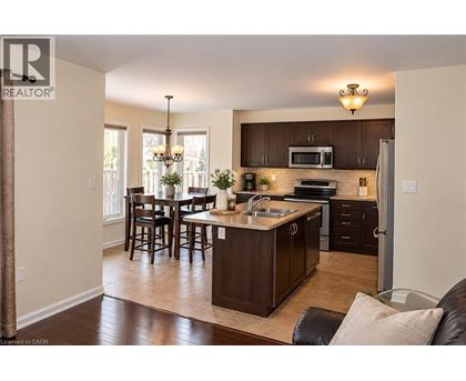A well-lit kitchen with dark wood cabinets and a central island.
