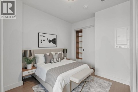 A bedroom with a bed, nightstand, and lamp.