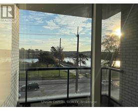 A view from a window of a parking lot and trees.