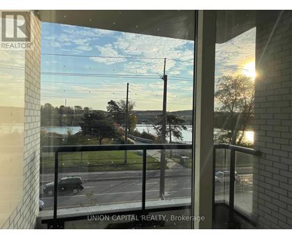 A view from a window of a parking lot and trees.