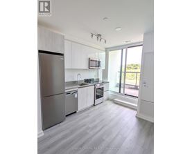 A kitchen with white cabinets and a stainless steel refrigerator.