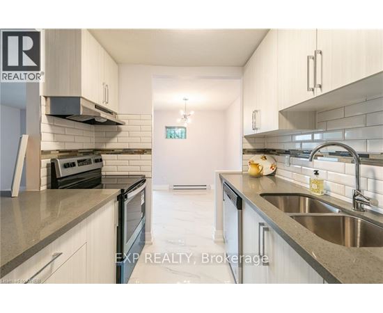 A modern kitchen with white cabinets and stainless steel appliances.
