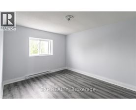A room with a window and wooden flooring.