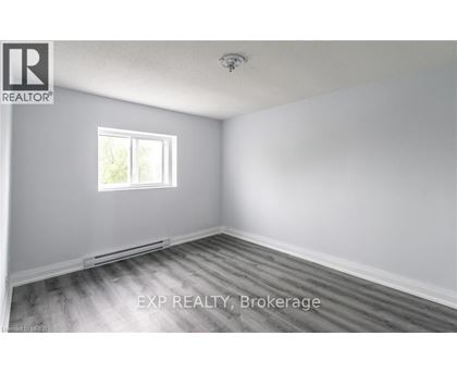 A room with a window and wooden flooring.