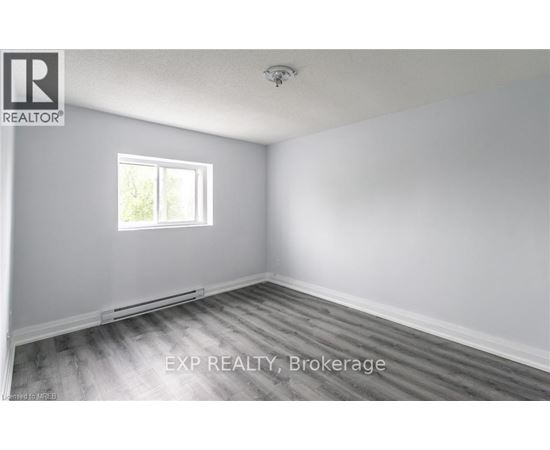 A room with a window and wooden flooring.