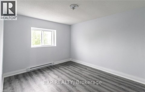 A room with a window and wooden flooring.