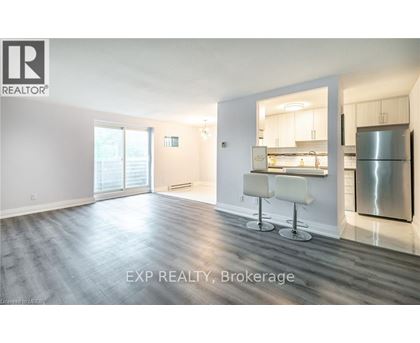 A spacious room with a kitchenette in the background.