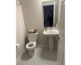 A man is reflected in a bathroom mirror.
