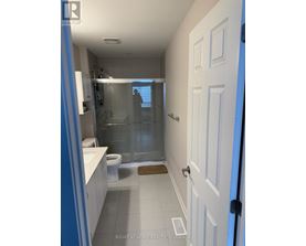 A bathroom with a white door and a glass shower stall.
