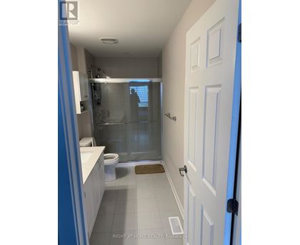 A bathroom with a white door and a glass shower stall.