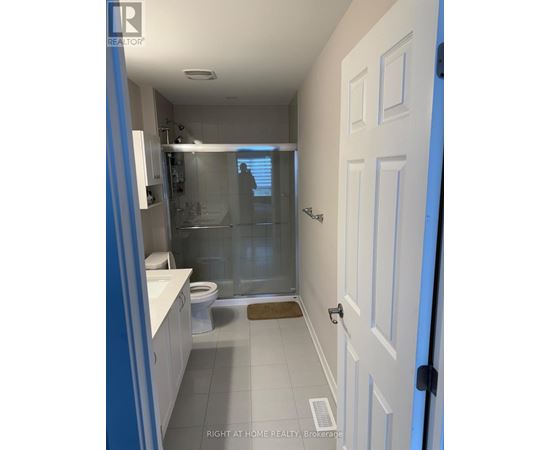 A bathroom with a white door and a glass shower stall.