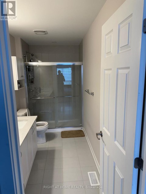A bathroom with a white door and a glass shower stall.