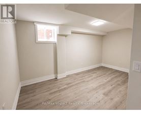 A room with light wood flooring and white walls.