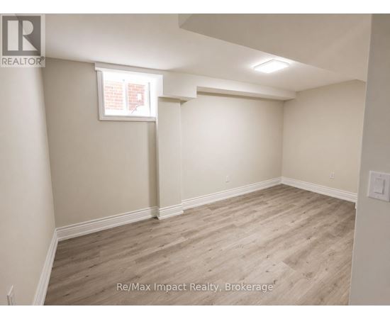 A room with light wood flooring and white walls.
