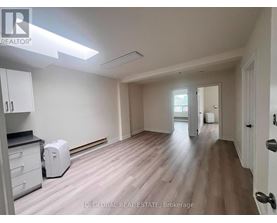 A room with a white toaster on the floor.