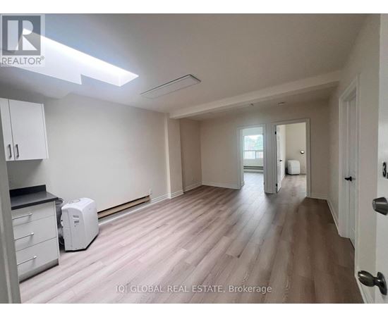 A room with a white toaster on the floor.