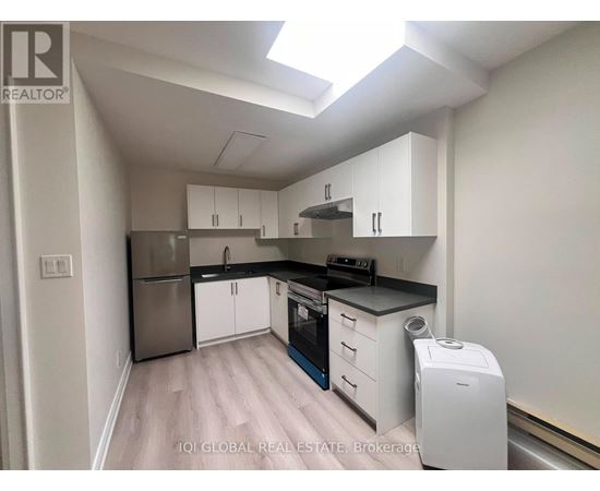 A kitchen with white cabinets and a stainless steel refrigerator.
