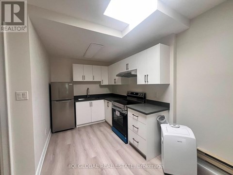 A kitchen with white cabinets and a stainless steel refrigerator.