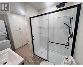 A bathroom with a white sink and a glass shower stall.