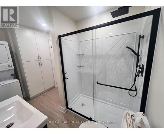 A bathroom with a white sink and a glass shower stall.