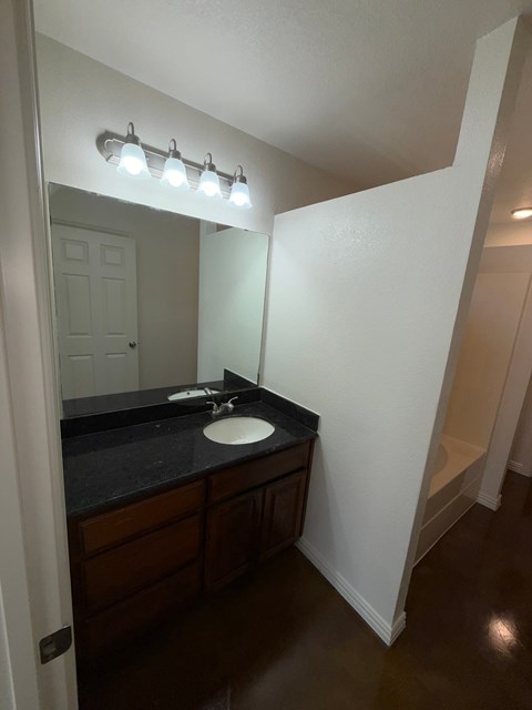 A bathroom with a sink and mirror.