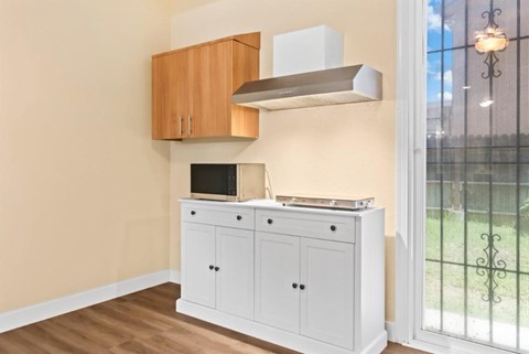 A kitchen with a white cabinet and a stove top oven.