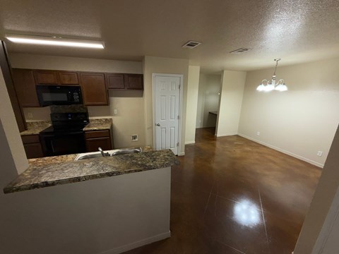 A kitchen with brown cabinets and a granite countertop.
