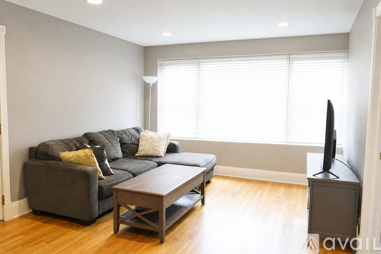 A living room with a grey couch, a coffee table, and a television.