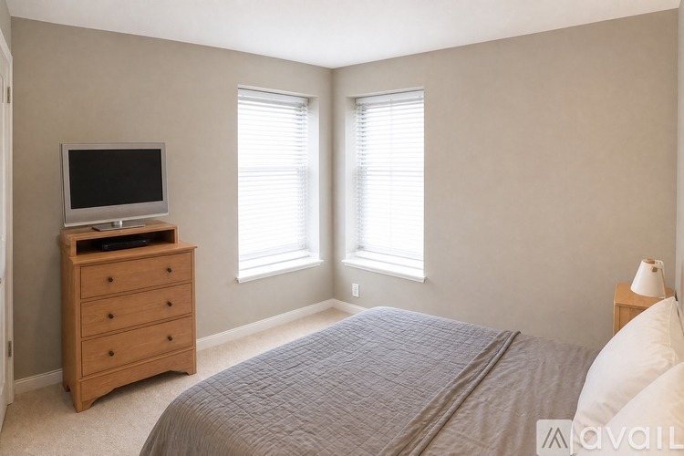 A bedroom with a bed, dresser, and television.
