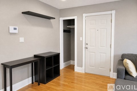 A living room with a grey couch and a black shelf unit.
