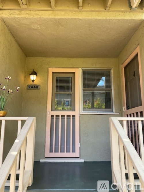 A house entrance with a pink door and a window.