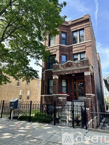 A brick building with a black gate in front.
