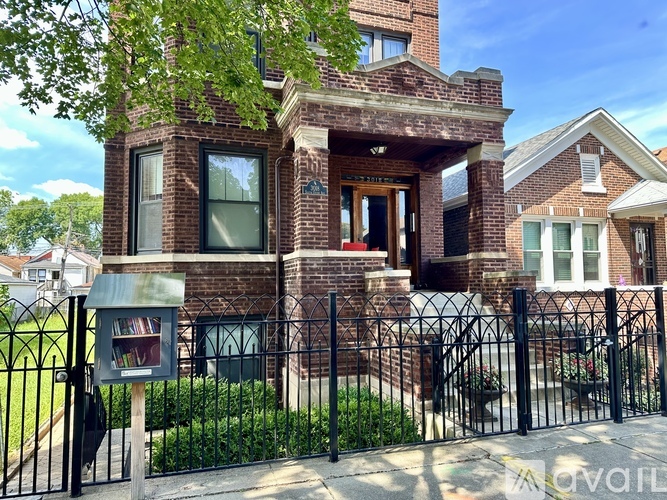 A brick house with a black gate and a mailbox.