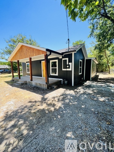 A small house with a porch and a covered entryway.