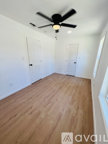 A room with wooden flooring and a ceiling fan.