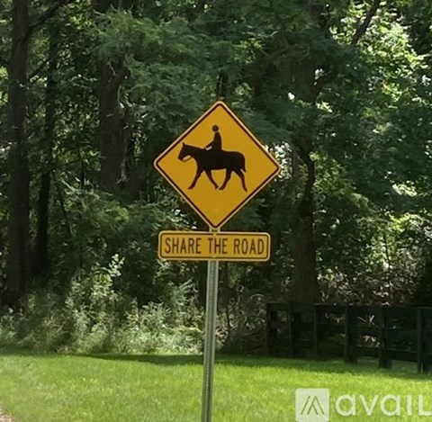 A sign warning of horse crossings and advising to share the road.