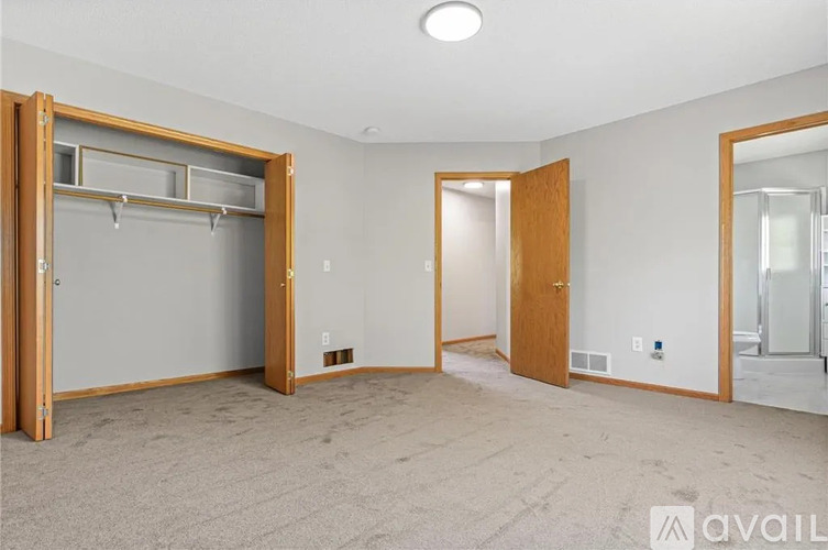 A spacious room with a large closet and a mirror on the wall.